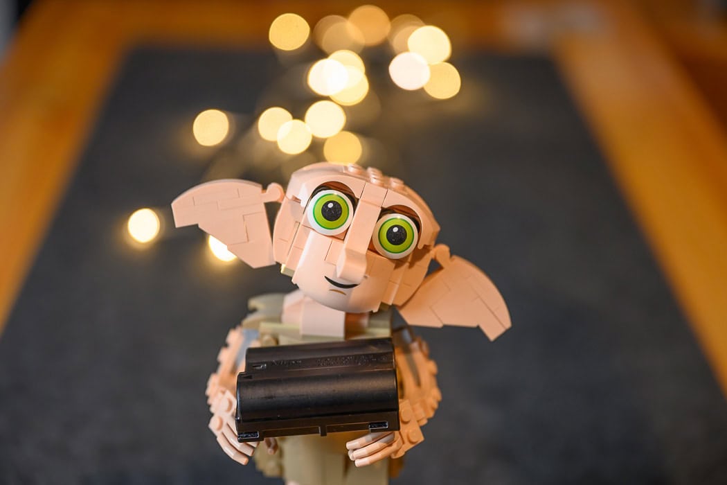 Dobbie the elf holding a battery with light in the background showcasing Nikon Z 24-70mm F2.8 Bokeh